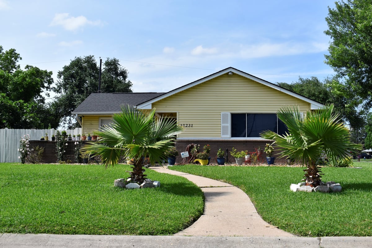Bright retro 1970s ranch-style single-family home with classic architecture, beautiful garden and lovely cloud coverage